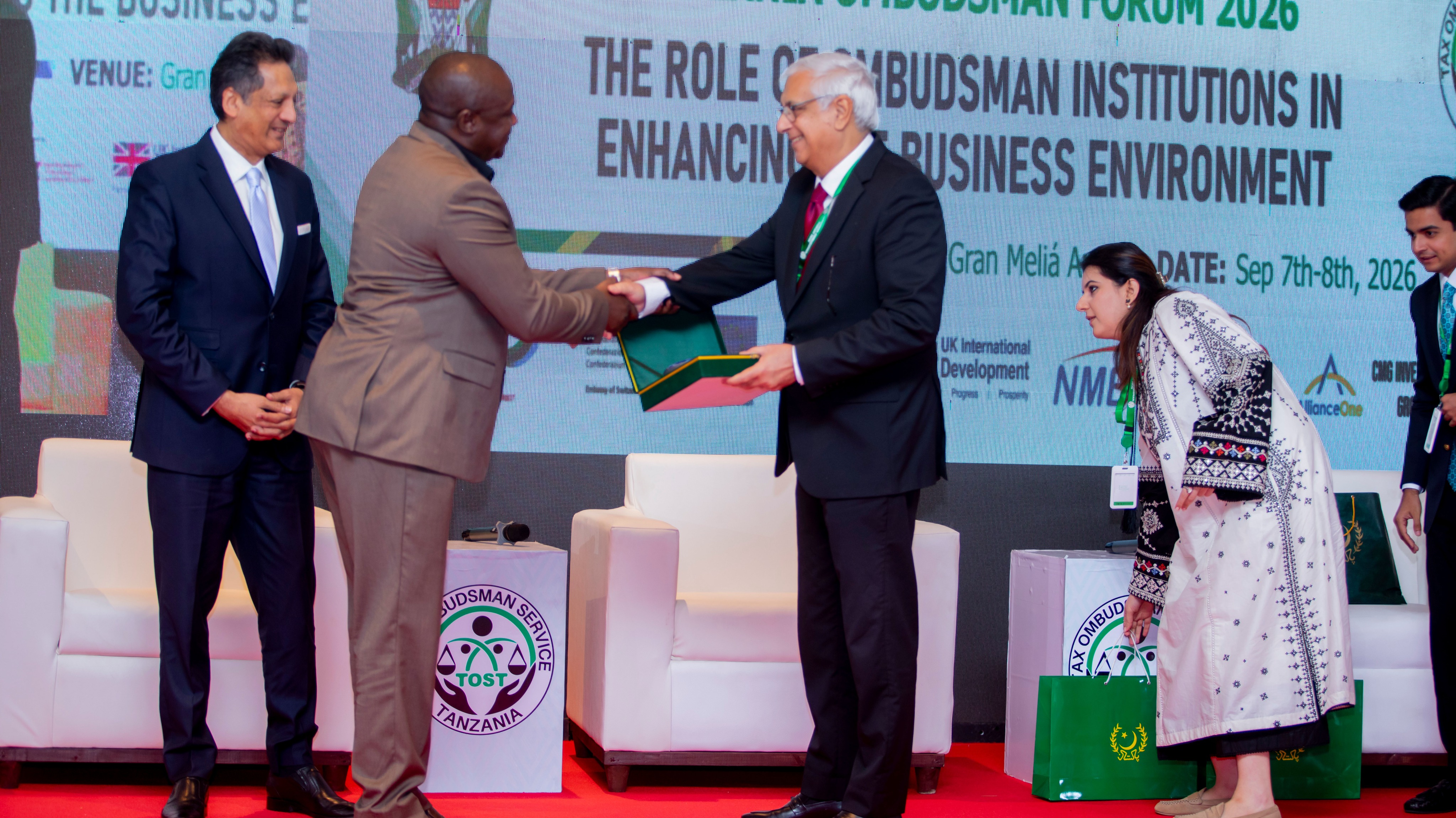 Mkuu wa Sehemu ya Sheria wa Ofisi ya Usuluhishi wa Malalamiko na Taarifa za Kodi (TOST) akipokea zawadi katika Mkutano wa Masuala ya Usuluhishi (Tanzania Ombudsman Forum 2026), uliofanyika tarehe 7–8 Septemba 2026 katika Hoteli ya Gran Meliá, jijini Arusha.